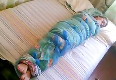 Barefoot girl mummified in a bedsheet